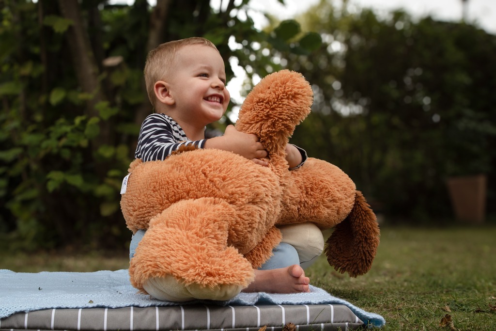 Lachendes Kind mit Kuscheltier